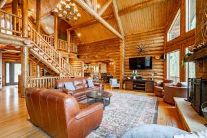 a living room with leather furniture in a log cabin at Bracken Lodge by Railey Vacations in Swanton