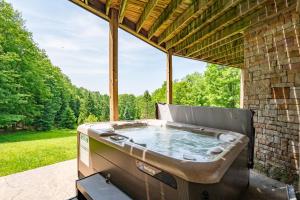 a hot tub sitting on a screened in porch with a view at Bracken Lodge by Railey Vacations in Swanton +46 photos
