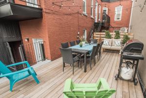 um pátio com uma mesa e cadeiras num deque em MTLVacationRentals - The FabFour em Montreal