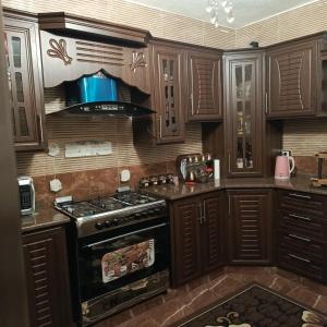 a kitchen with wooden cabinets and a stove top oven at المناره هاوس in Wadi Musa