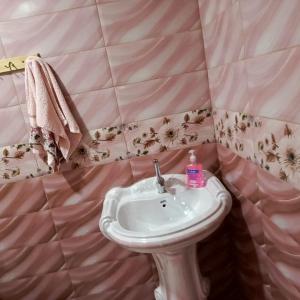 a bathroom with a sink and a pink tiled wall at المناره هاوس in Wadi Musa