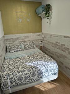 a bedroom with a bed with a black and white comforter at AEROPUERTO BARCELONA -Mi colibrí in El Prat de Llobregat