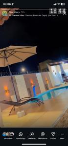 a picture of an umbrella on the beach at night at Tô A Tôa in Touros +4 photos