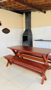 a wooden bench sitting in a room with a fireplace at Tô A Tôa in Touros