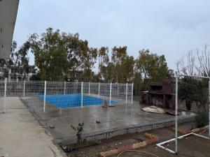 a fence in front of a swimming pool at Happy farm in Erbil +13 photos