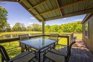 a patio with a table and chairs on a deck at Modern Pond-View Cabin Near Lake of Egypt in Marion