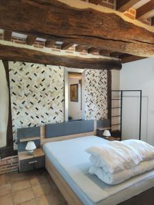 a bedroom with a large white bed with wooden ceilings at Gîtes les Deux Vallées in Le Bois-Hellain