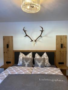 a bedroom with a bed with a deer head on the wall at Haus Steinplatte in Waidring