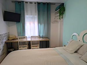 a bedroom with a bed and two chairs and a window at BARCELONA AIRPORT Mi COLIBRÍ in El Prat de Llobregat