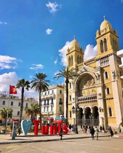 a large building with palm trees in front of it at Hotel Marhaba - Beb Bhar Tunis in Tunis