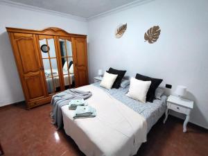 a bedroom with a large bed and a wooden cabinet at Rincón de Joel Habitación con baño privado in La Orotava