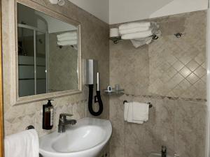 a bathroom with a sink and a mirror and towels at Hotel Dei Tartari in Guidonia +28 photos