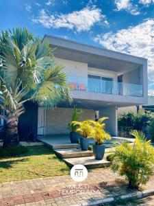 a house with palm trees in front of it at Rosa Internacional - Surfland in Praia do Rosa +68 photos
