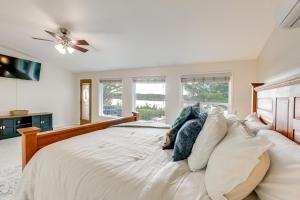 a bedroom with a large bed with a ceiling fan at Private Beach, Deck & Grill! Siuslaw River Getaway in Florence