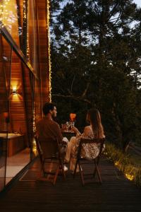 a man and woman sitting at a table on a patio at Cabana com banheira in Gramado