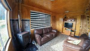 a living room with a couch and a stove at Cabañas Victoria Aucaco in Ancud