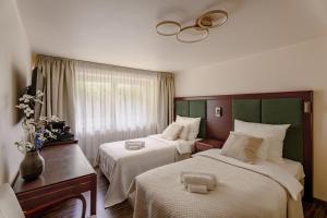 a hotel room with two beds with white sheets at Willa RIVA in Wisła