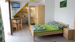 a small bedroom with a bed and a dining room at Agroturystyka Pod Zamczyskiem in Sromowce Wyżne