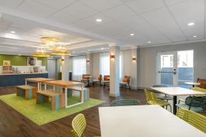 a rendering of a cafeteria with tables and chairs at Spark by Hilton Murfreesboro in Murfreesboro