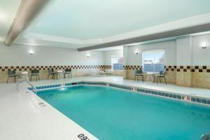a large swimming pool with chairs and a table at Spark by Hilton Murfreesboro in Murfreesboro