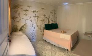 a small room with a bed and a bed sidx sidx sidx at Quarto Aconchego Nordestino in Aracaju