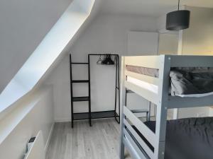 a room with two bunk beds and a ladder at maison cosy proche du port et plage in Grand-Fort-Philippe