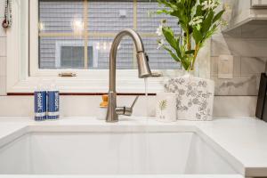 a kitchen sink with a faucet and a window at Charming Boston Retreat 3BR Parking Perfect for Families & Groups in Revere +34 photos