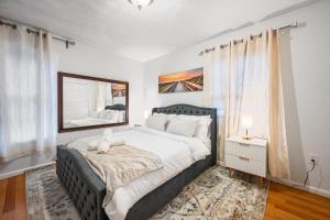 a bedroom with a large bed and a mirror at Charming Boston Retreat 3BR Parking Perfect for Families & Groups in Revere