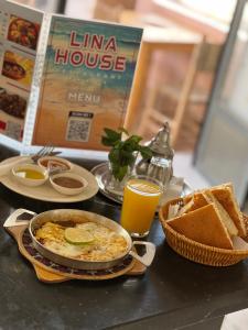 a table with a pan of food and bread and orange juice at lina imsouane in Imsouane