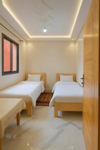 a room with two beds and a window at lina imsouane in Imsouane
