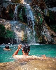 a man in the water near a waterfall at Sahan geust inn in Wellawaya
