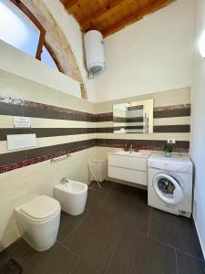 a bathroom with a toilet and a washing machine at Il Cortiletto di Ortigia in Syracuse +25 photos