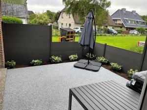 an umbrella sitting on a patio with a fence at Seaside-Amrum-5 in Norddorf