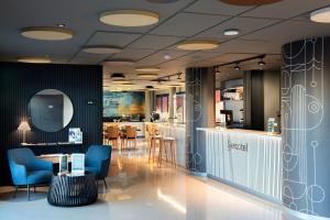 a lobby with chairs and a table and a bar at Hotel Sercotel Plana Onda in Onda