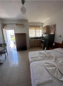 a hotel room with two beds and a kitchen at Nova Marine in Souda