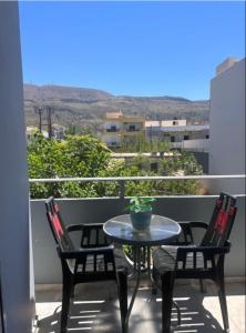 a patio with a table and two chairs on a balcony at Nova Marine in Souda