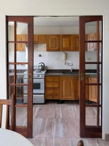 a kitchen with wooden cabinets and a stove at Departamento Torre IV in Comodoro Rivadavia