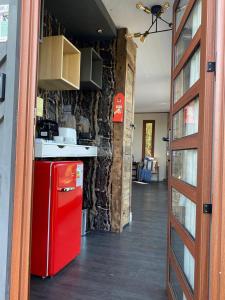 a kitchen with a red refrigerator next to a stone wall at Nidos de Apalta in Santa Cruz