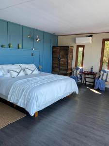 a bedroom with a large bed with a blue wall at Nidos de Apalta in Santa Cruz