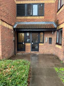 an entrance to a brick building with glass doors at Tranquil 1BD in Edmonton in Ponders End