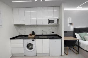 a kitchen with a washing machine in a white kitchen at Ap Fuenlabrada in Fuenlabrada