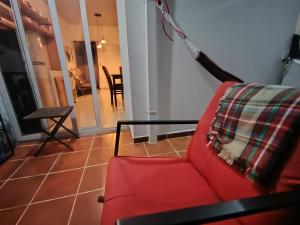 a living room with a red couch and a table at Casa Socorrito in Ahuachapán +2 photos