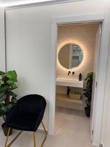 a bathroom with a mirror and a black chair at Ap Fuenlabrada in Fuenlabrada +3 photos