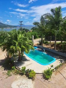 an overhead view of a swimming pool with palm trees at Sobradinho Morro dos Ventos in Palhoça