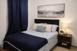 a bedroom with a bed with a blue comforter at Casa Socorrito in Ahuachapán