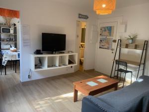 a living room with a tv and a couch and a table at OCEAN PLAGE Appartement-terrasse-garage-wifi-draps et serviettes in Hendaye