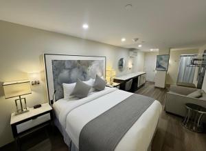a hotel room with a large bed and a couch at Nova Hotel JFK in Hillside