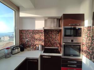 a kitchen with a stove top oven next to a window at Stargaze Apartment with Sea View by MindYourVilla in Zakynthos