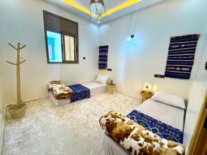 a room with two beds and a cross on the wall at Surf Apartment in Tamri Rooftop Local Experience in Tamri