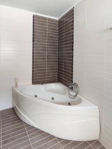 a white bath tub in a bathroom with tiles at Stargaze Apartment with Sea View by MindYourVilla in Zakynthos +29 photos